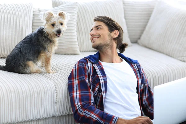 성공적인 남자와 아늑한 거실에 있는 그의 가장 좋아하는 애완 동물. — 스톡 사진