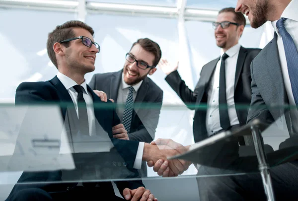 Dolnej view.business partnerów, drżenie rąk, siedząc przy biurku — Zdjęcie stockowe