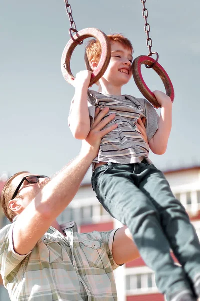 Fadern lär sin son att komma ikapp på baren. — Stockfoto