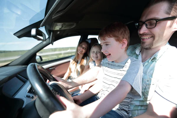 Padre divertente e il suo piccolo figlio alla guida di una macchina — Foto Stock