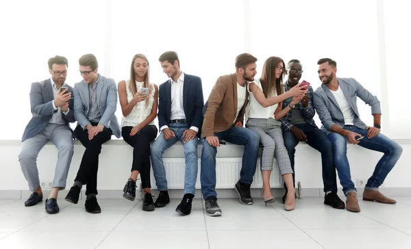 Grupa młodych ludzi komunikować się w poczekalni. — Zdjęcie stockowe