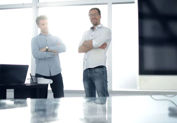 Fondos de negocios.dos empleados de pie en una oficina moderna . — Foto de Stock