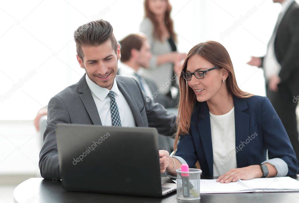 man and woman sitting at table in co-working office