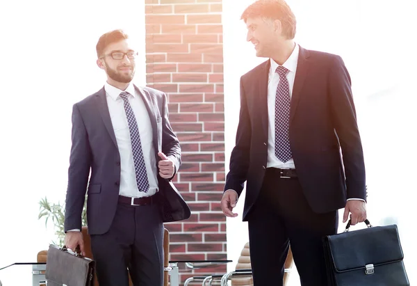 Dos hombres de negocios caminando por el moderno edificio de oficinas — Foto de Stock