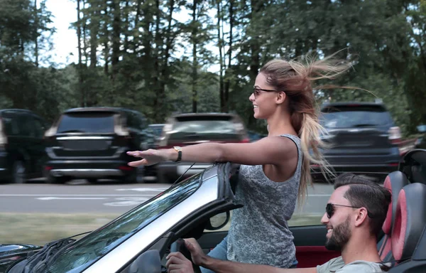 Couple of lovers driving on a convertible car