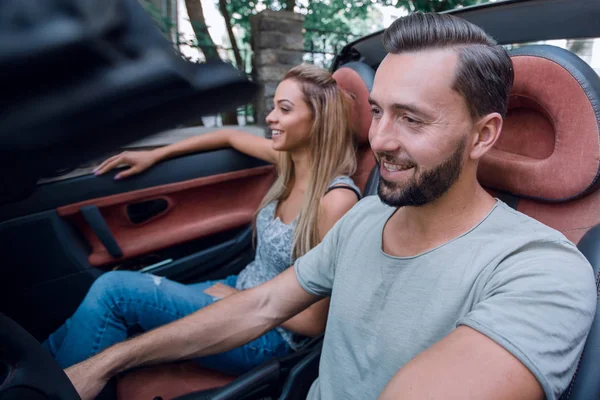 Homem de sucesso sentado ao volante de um carro de luxo — Fotografia de Stock