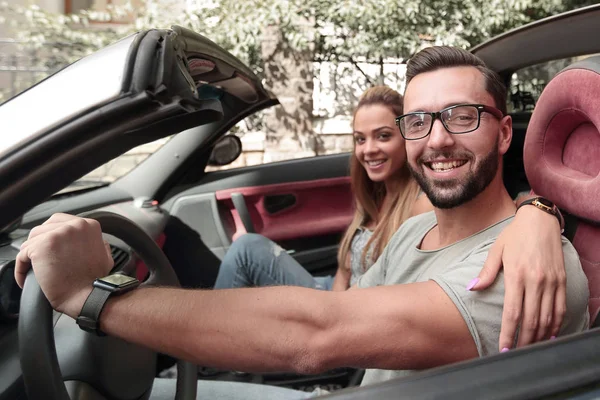 Jovem casal dentro de um carro conversível para uma viagem de um dia . — Fotografia de Stock
