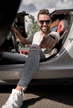 up.fashionable genç adam oturan bir Cabrio ve poin kapatın