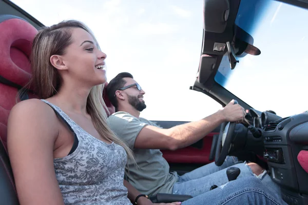 Pareja feliz sentada en un coche descapotable — Foto de Stock