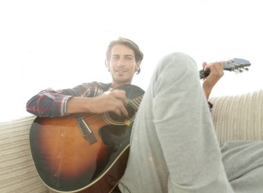 oturma odasında kanepede oturup gitar ile Modern adam.