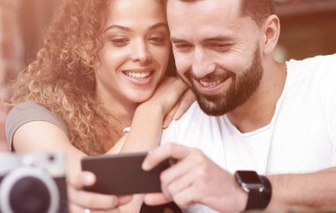 Mutlu çift Teras içinde oturan bir smartphone kullanarak