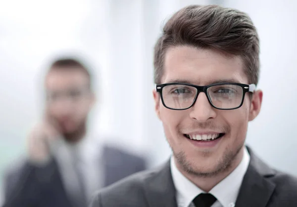 Close up. smiling young businessman in the office background — стоковое фото