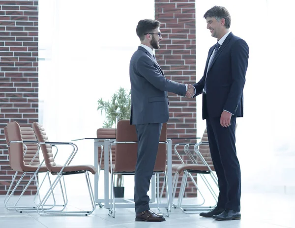 Dos empresarios se dan la mano en la oficina — Foto de Stock