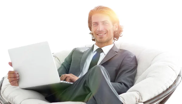Homem de negócios moderno com um laptop sentado em uma cadeira confortável elegante — Fotografia de Stock
