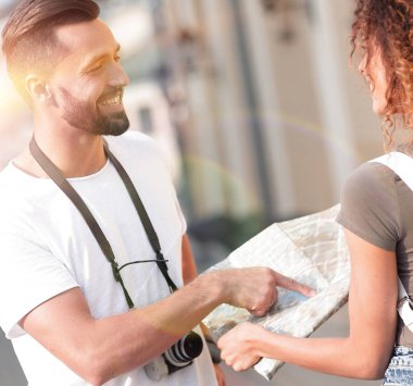 Genç çift mutlu görünürken bir rehbere bakıyor.