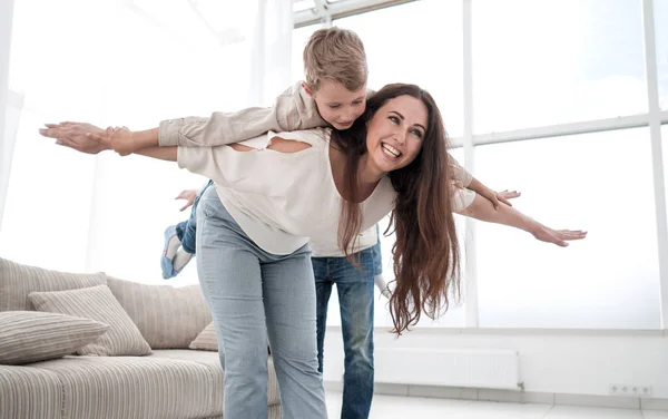 Madre juega con su hijo en una amplia sala de estar — Foto de Stock