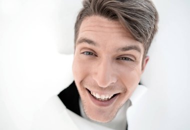 Gazetede bir delikten bakarak gülen adam