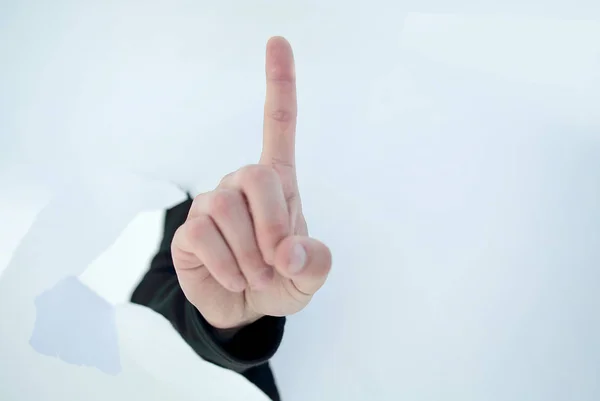 Close up.businessman mostrando seu dedo indicador através do p rasgado — Fotografia de Stock