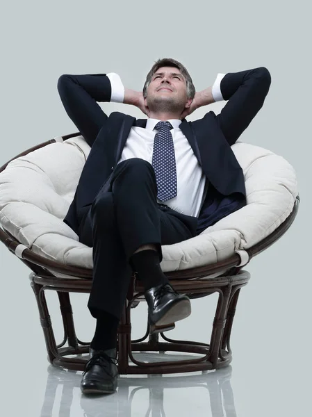 Homme d'affaires rêveur se repose, assis dans une grande chaise douce . — Photo