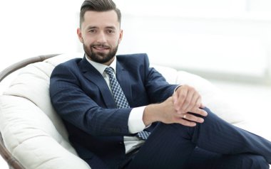 Kendine güvenen işadamı bir sandalyede oturuyor