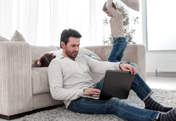Hombre con un portátil sentado en la sala de estar — Foto de Stock