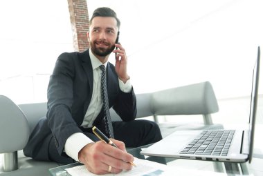 İşadamı Smartphone'da finansal belgeler hakkında konuşmak