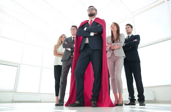 Líder en la capa roja y el equipo de negocios de pie juntos — Foto de Stock