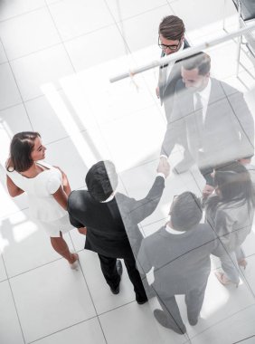 Çalışanların arasında el sıkışan iş adamları..