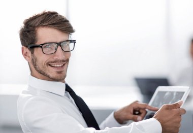 İşadamı ofiste tabletini kullanıyor.