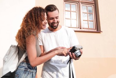 Fotoğraflara bakarak yürüyen genç arkadaşların portresi