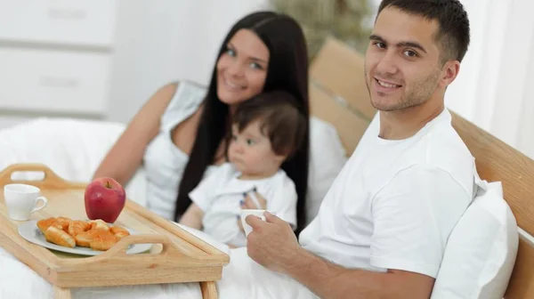 Famille prenant le petit déjeuner au lit à la maison — Photo