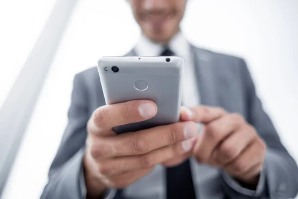 Affärsman tittar på mobiltelefon i office — Stockfoto