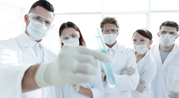 Background image is a group of medical workers working with liquids in laboratory — Stock Photo, Image