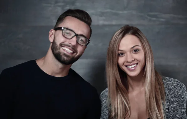 Lyckliga paret leende på en grå bakgrund — Stockfoto