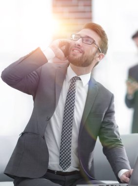 Ofiste kendine güveni tam genç bir adam konuşuyor.