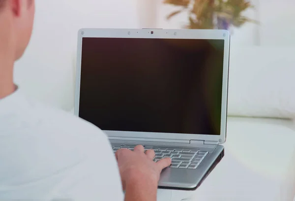 Vista trasera primer plano de un joven que trabaja en un ordenador portátil . — Foto de Stock