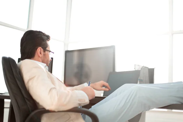 Affärsman som sitter vid sitt skrivbord under en arbetande paus — Stockfoto