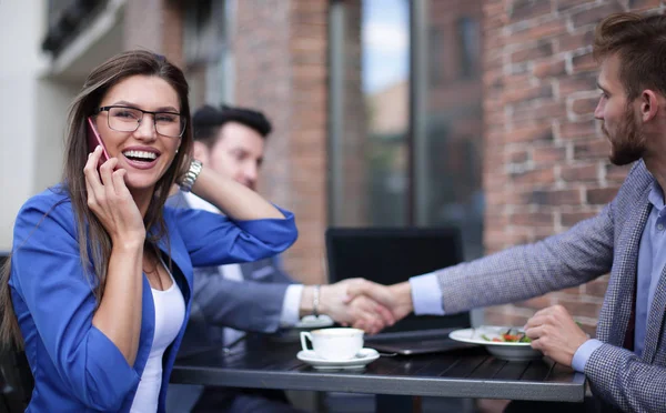 Geschäftsfrau telefoniert in einem Straßencafé — Stockfoto