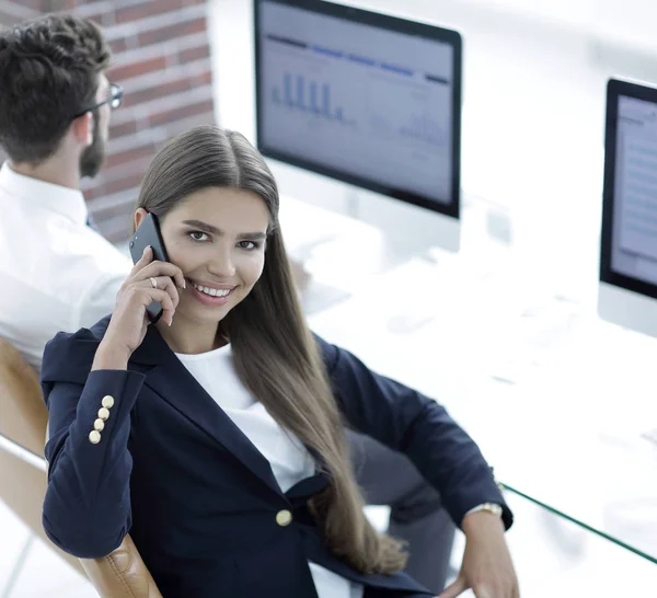 Seriöse Mitarbeiterin spricht auf seinem Handy — Stockfoto