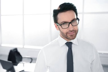 Geniş bir ofiste kendine güvenen bir iş adamı