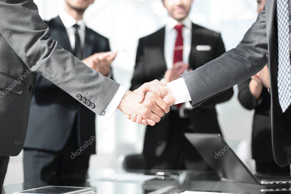 handshake of financial partners in the office
