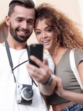 Mutlu genç çift cep telefonuyla yer arıyor.