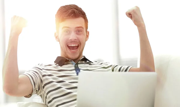 Homem feliz com laptop sentado no sofá — Fotografia de Stock