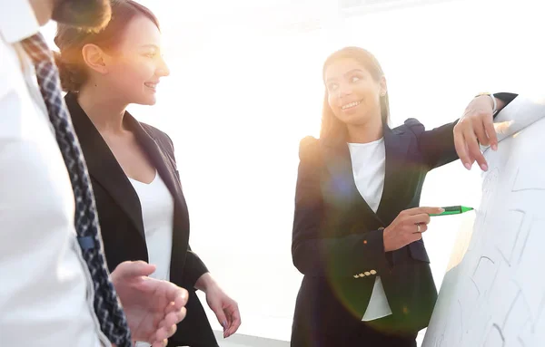 Mujer de negocios señalando con un marcador en el rotafolio — Foto de Stock