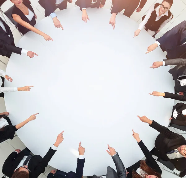 Closeup .business team wijzen in het midden van de tafel. — Stockfoto