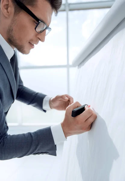 Guapo hombre de negocios maduro escribiendo en un rotafolio vacío — Foto de Stock