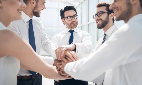 Primer plano. Un equipo de negocios sonriente se para con las manos dobladas — Foto de Stock