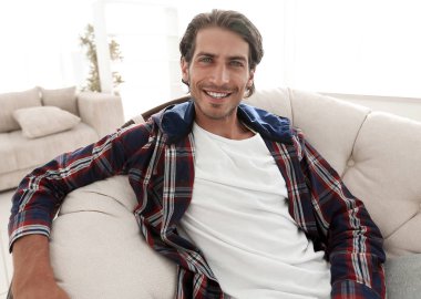 başarılı adam modern oturma odasında dinleniyor.