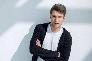 beyaz duvara yakın duran dalgın genç adam.