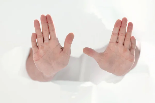 Człowiek, przedzierając się przez ścianę papieru i pokazuje gest stop — Zdjęcie stockowe